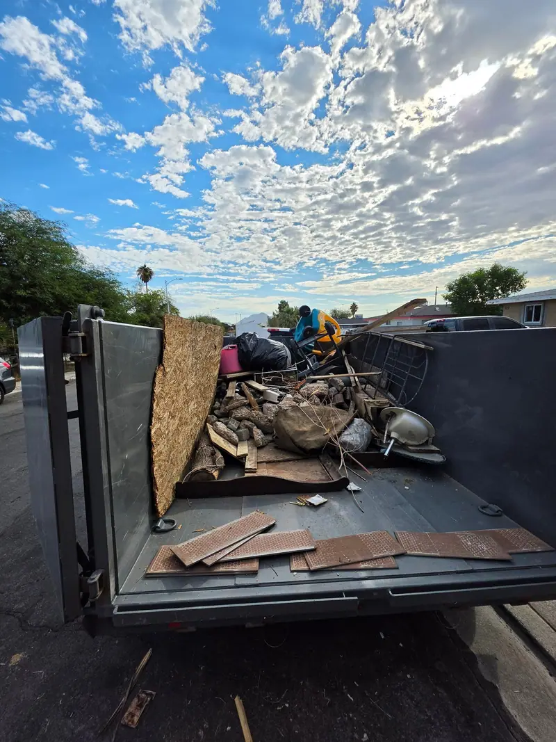Scrap wood and remodel debris in the trailer under a cloudy sky
