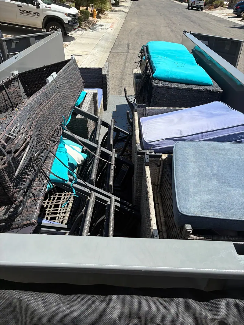 Patio chairs, cushions and a mattress loaded in the dump trailer