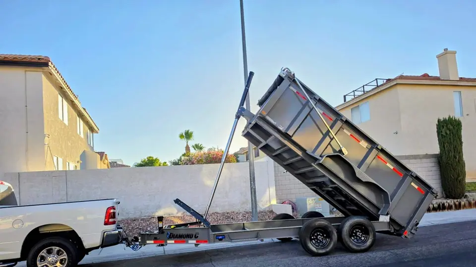 Legend Hauling pickup and gray dump trailer with the bed raised on a Las Vegas valley street
