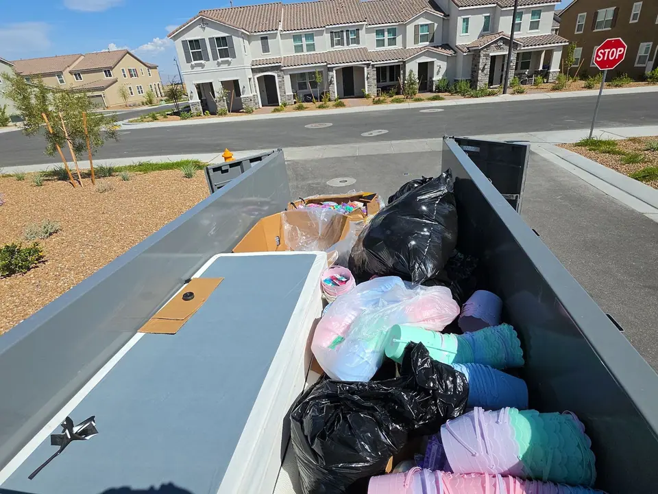 Trailer loaded with a box spring and bags outside new townhomes in the Las Vegas valley