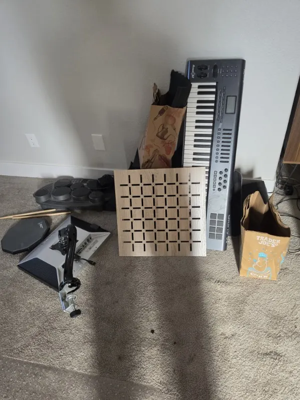 Keyboard, drum pads and studio gear set against a wall for pickup