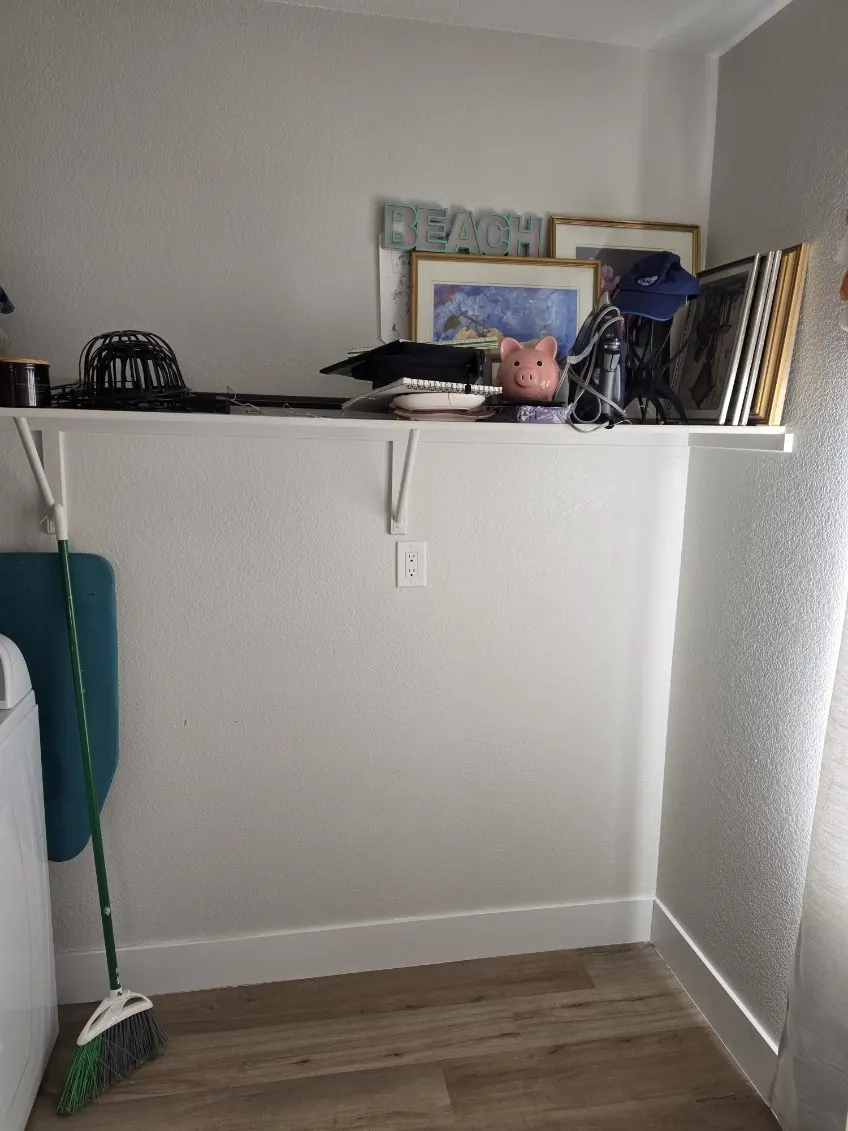 The same laundry nook after, floor clear and the shelf down to a few keepsakes