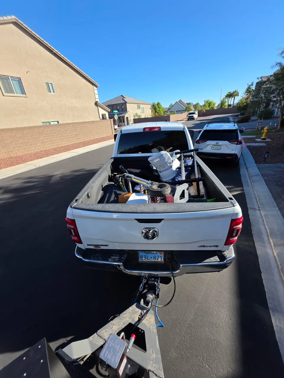 Loaded pickup towing the dump trailer down a residential street