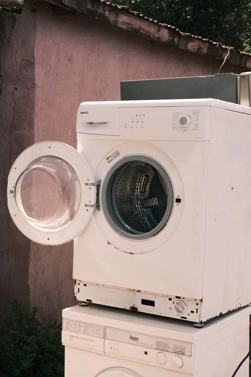 Old washer and dryer set outside against a pink wall (representative photo)