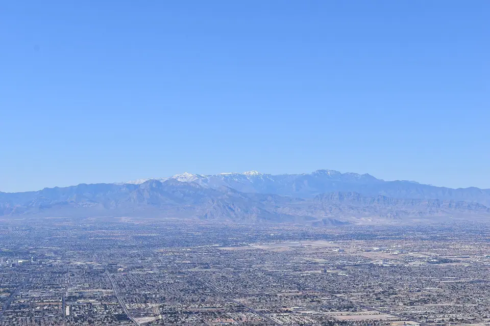 The Spring Mountains rising over the Las Vegas Valley housing grid, daylight; Spring Valley sits at the foot of this range, Spring Valley, NV